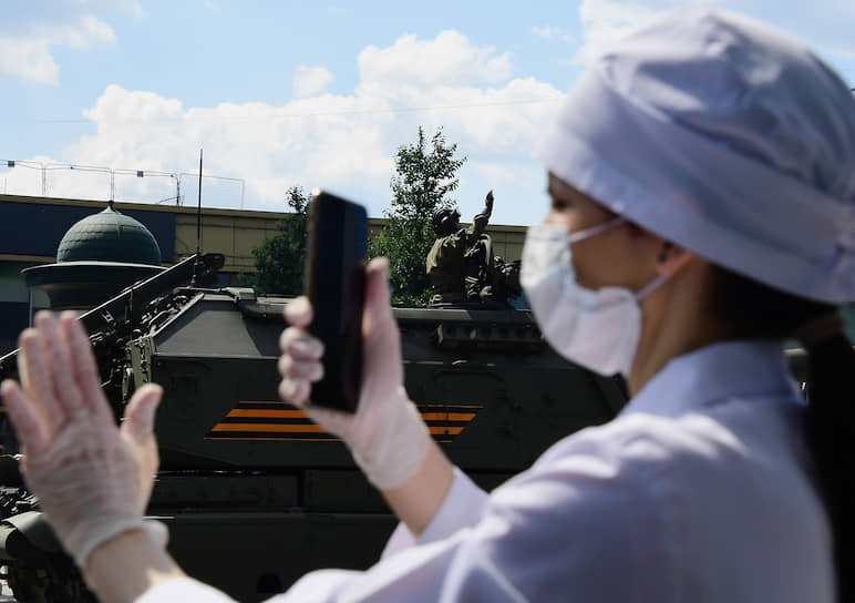 Девушка снимает на телефон проезд военной техники по улице Новый Арбат