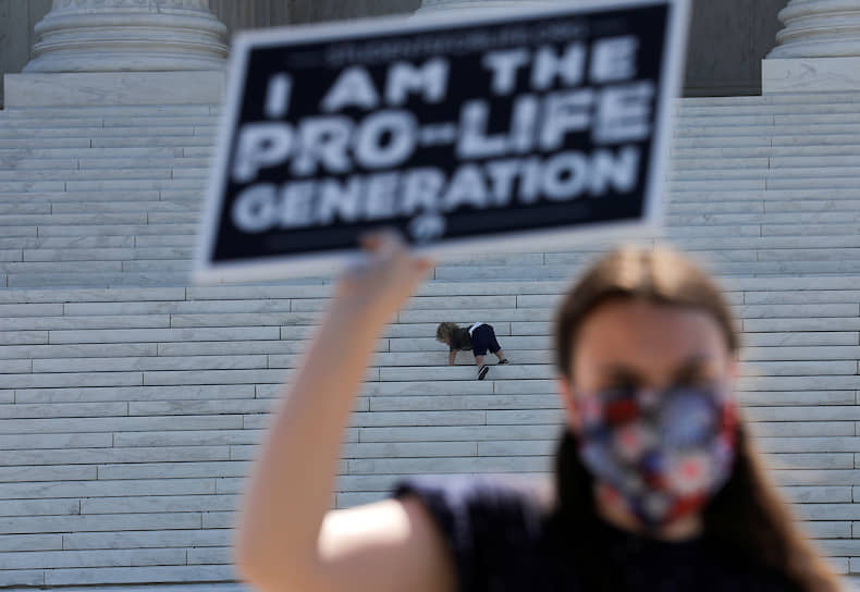 Вашингтон, США. Активистка, выступающая против абортов, на фоне ребенка возле здания Верховного суда
