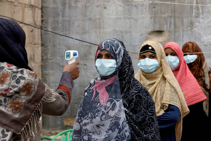 Карачи, Пакистан. Женщины стоят в очереди на измерение температуры