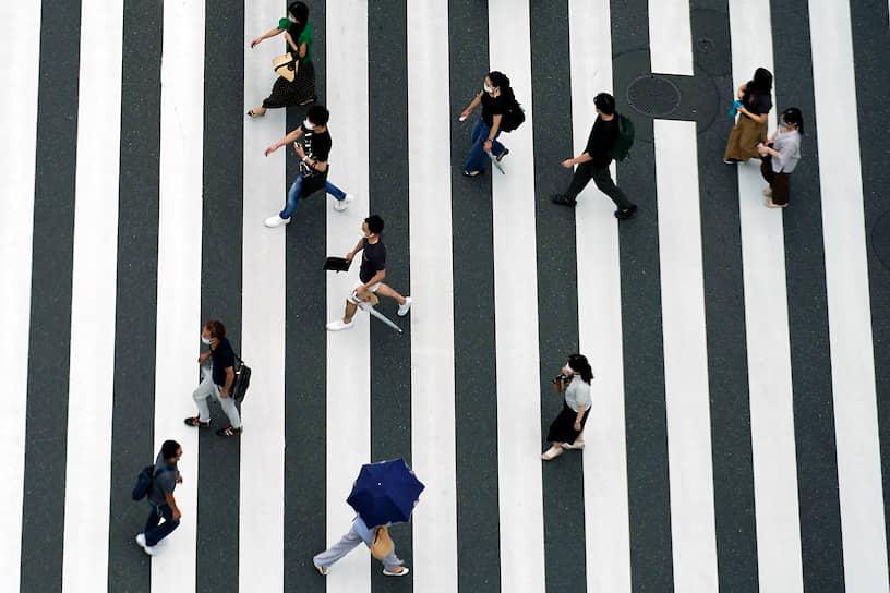 Токио, Япония. Люди в защитных масках на пешеходном переходе