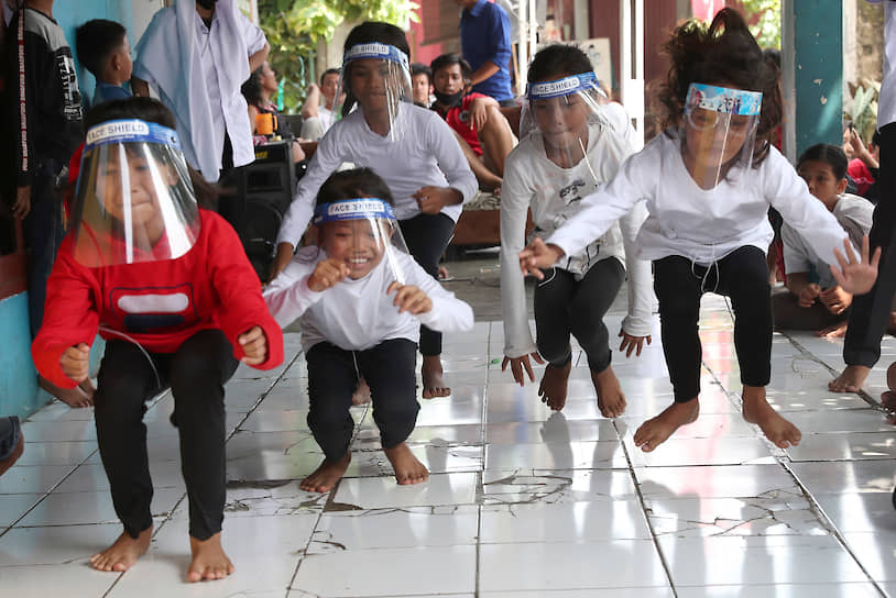 Тангеранг, Индонезия. Дети прыгают наперегонки в защитных масках 