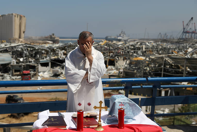 Ливан, Бейрут. Католический священник готовится к мессе в районе места взрыва в порту 