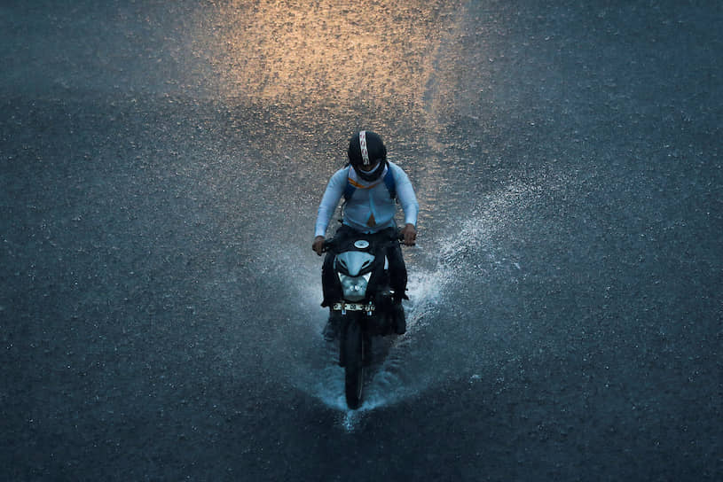 Нью-Дели, Индия. Мужчина едет на мотоцикле во время дождя