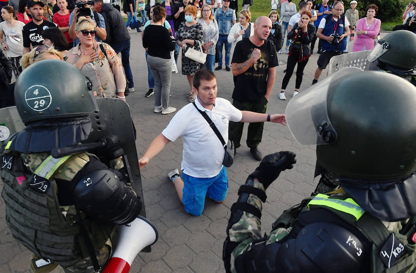 Участник акции стоит на коленях перед сотрудниками правоохранительных органов