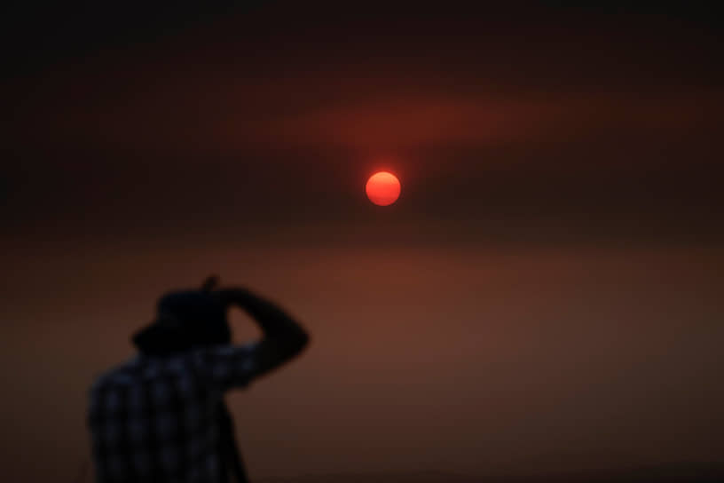 Вид на закат солнца через дым от пожаров 