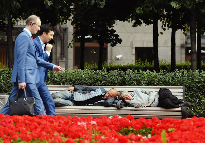 Москва. Мужчины в деловых костюмах проходят мимо лавочки со спящими людьми