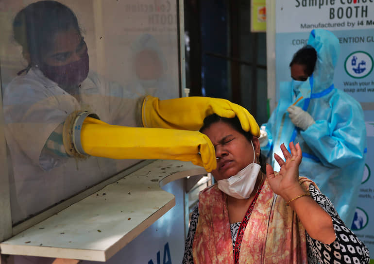 Хайдарабад, Индия. Медработница берет у местной жительницы мазок для теста на коронавирус 