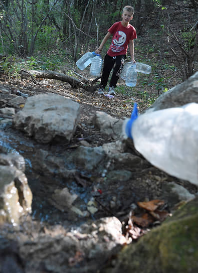 Из-за засухи в некоторых районах Крыма введены графики подачи воды.&lt;br>
На фото: мальчик с бутылками у родника