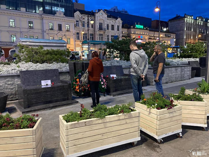 Жители Владивостока несут цветы к гранитным скамейкам в городе