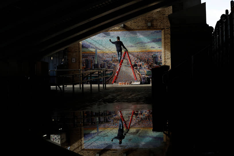 Лондон, Великобритания. Уличный художник за работой 