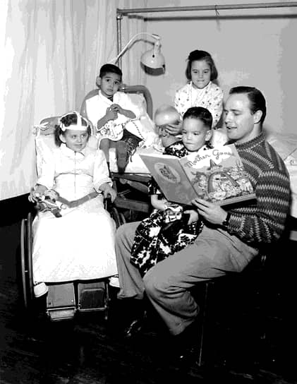 Актер Марлон Брандо читает «Сказки матушки Гусыни» больным полиомиелитом детям в ортопедической больнице в Лос-Анджелесе, 1956 год
