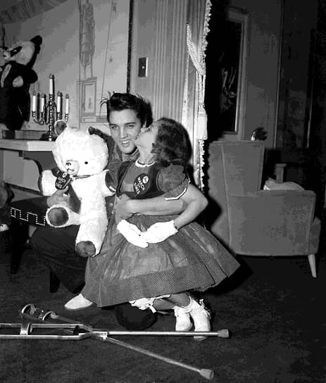 Певец Элвис Пресли с Мэри Кослоски, девочкой с плаката «Марш даймов», и плюшевым медведем, предназначенным для продажи с благотворительного аукциона