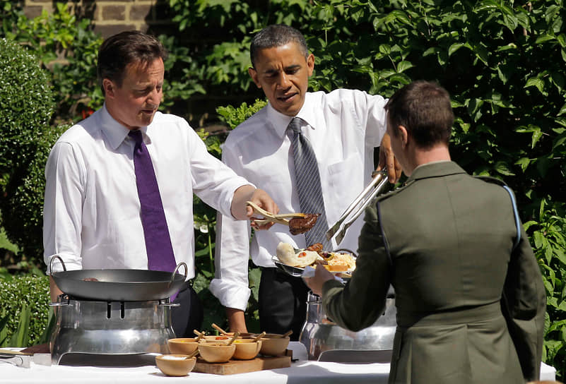 44-й президент США Барак Обама (в центре) — любитель фастфуда. «Барак с удовольствием ест картошку-фри с сальсой и гуакамоле. А также арахис, миндаль и орехи пекан», — рассказала в одном из интервью его жена Мишель. Бывший премьер Великобритании Дэвид Кэмерон (слева) любит готовить сам, особенно острую колбасную солянку&lt;br>
На фото: барбекю на Даунинг-стрит в Лондоне, 2011 год
