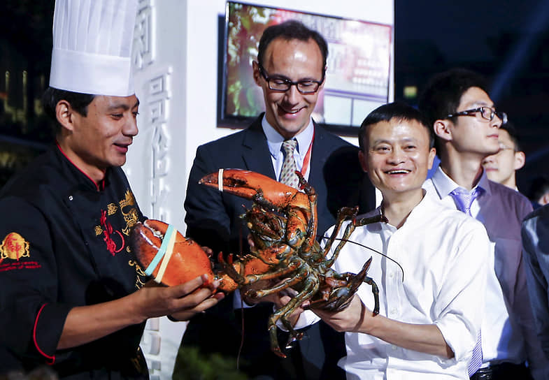 Основатель Alibaba Group Джек Ма (справа) демонстрирует приготовленного лобстера на выставке поставщиков свежих пищевых продуктов в 2015 году