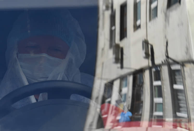 Севастополь. Водитель в защитном костюме и медицинской маске за рулем машины скорой помощи