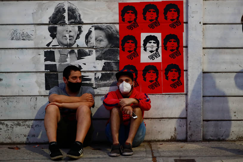Жители Буэнос-Айреса сидят под постерами с Диего Марадоной 