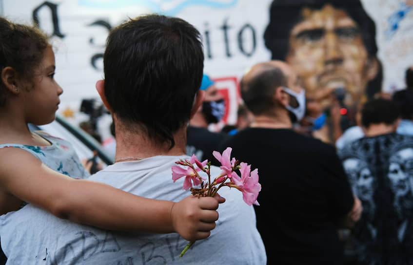 Люди несут цветы к стадиону имени Марадоны в Буэнос-Айресе 
