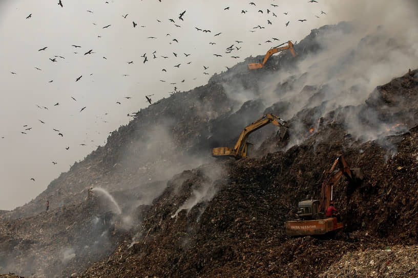 Нью-Дели, Индия. Пожарные пытаются потушить горящий мусор на полигоне