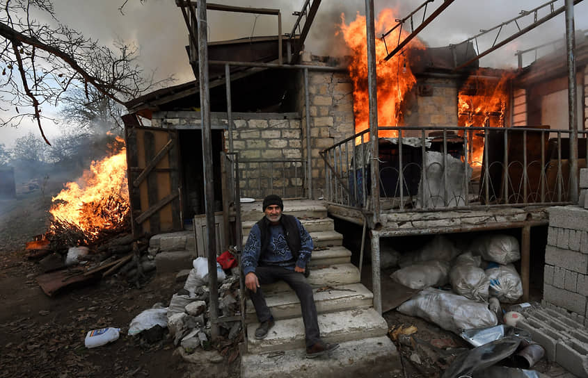 Карегах, Нагорный Карабах. Местный житель возле горящего дома в Лачинском районе, который должен отойти Азербайджану по условиям мирного соглашения