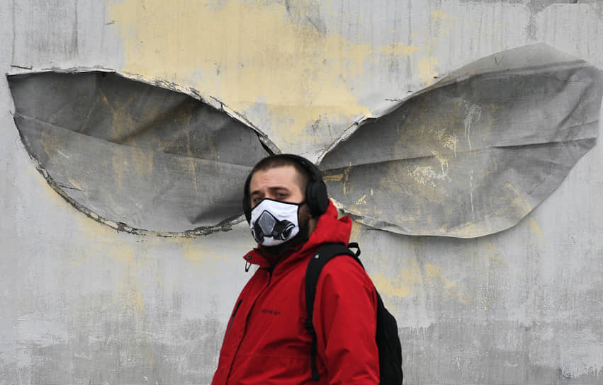 Мужчина в маске возле здания Главпочтамта в Москве 