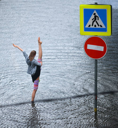 Девушка на затопленной из-за ливня проезжей части в Москве 
