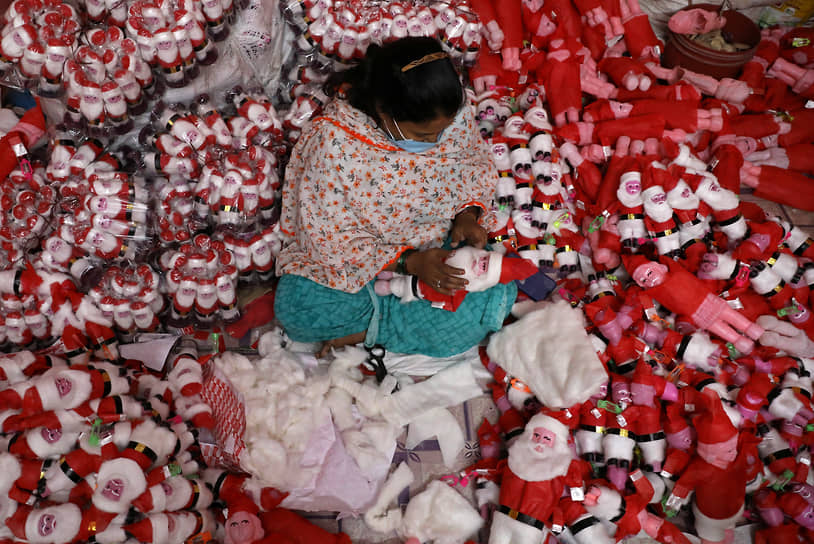Калькутта, Индия. Женщина изготавливает фигурки Санта-Клауса