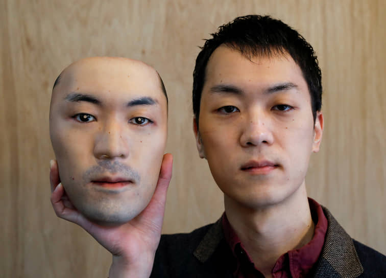 Токио, Япония. Мужчина держит маску, созданную с помощью 3D-печати
