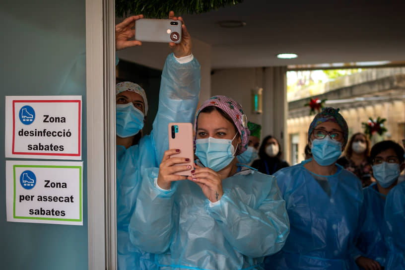 Барселона, Испания. Медработники фотографируют доставленную им вакцину от коронавируса 