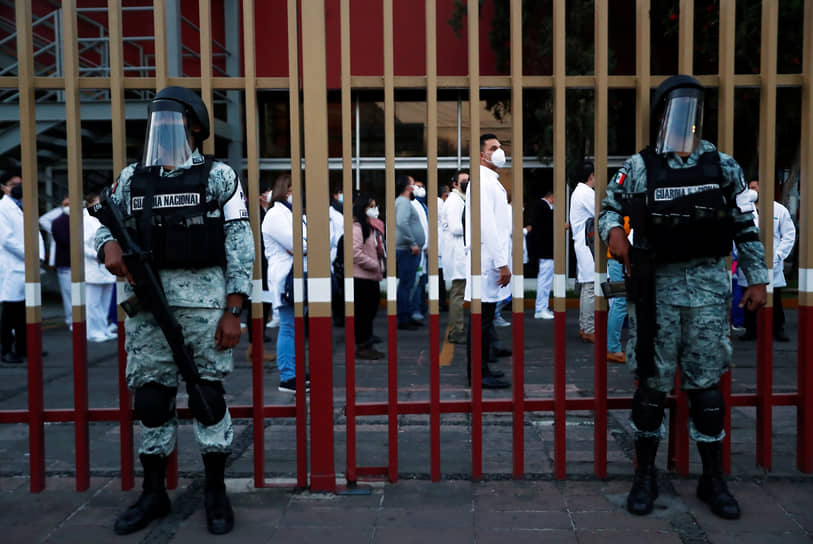 Мехико, Мексика. Солдаты Нацгвардии на фоне медперсонала, ожидающего инъекцию вакцины