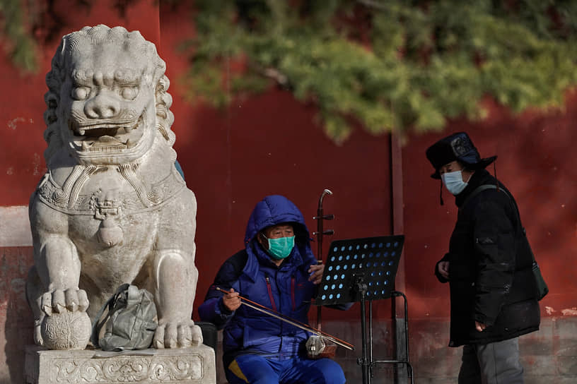 Пекин, Китай. Уличный музыкант играет в парке