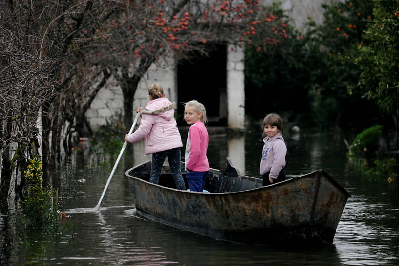 Обот, Албания. Дети плывут на лодке по затопленной деревне 