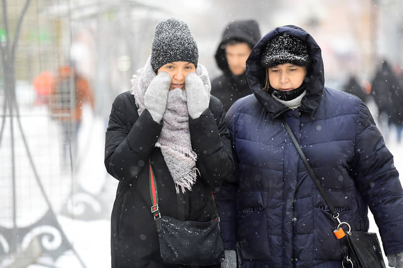 Люди на улицах города во время снегопада