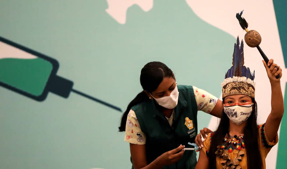 Манаус, Бразилия. Представительницу коренной народности уитото вакцинируют от коронавируса
