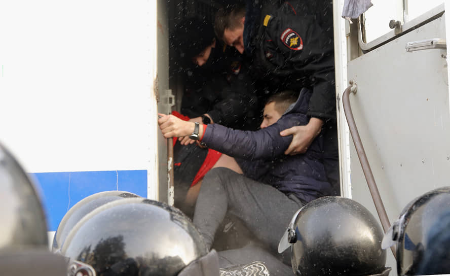 Сотрудники полиции во время задержания и посадки в автозак участника митинга в Новосибирске