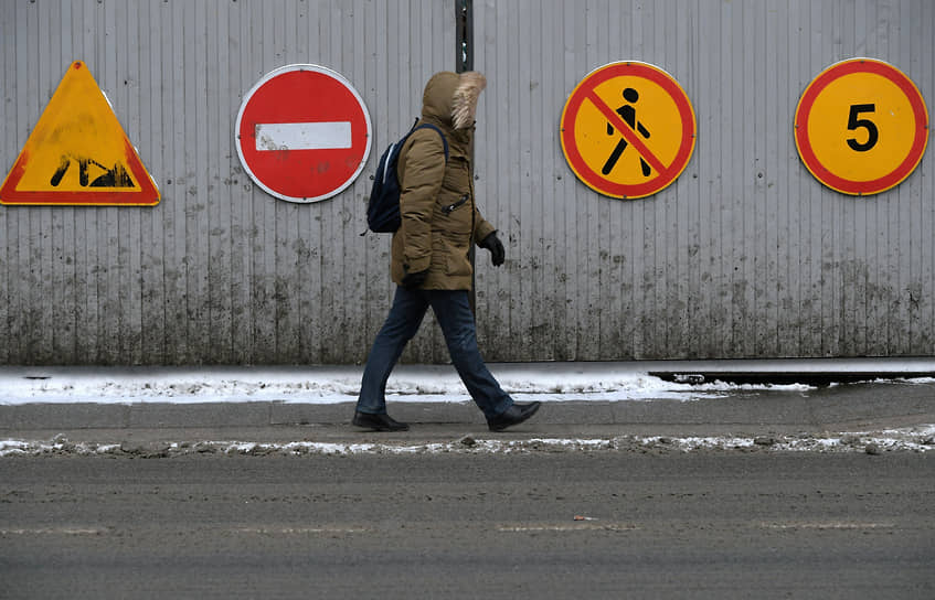 Москва, Россия. Прохожий на фоне дорожных знаков 