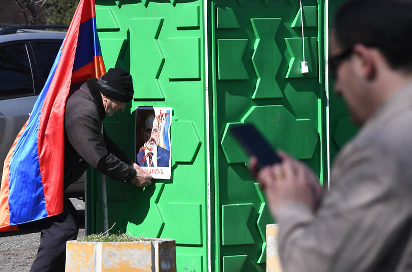Мужчина возле портрета премьера Армении Никола Пашиняна 