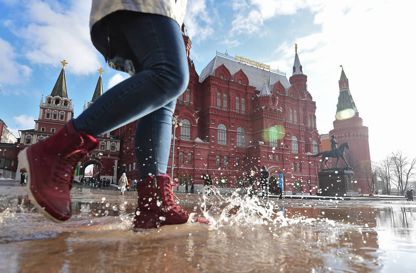 26 февраля. Москва. Девушка идет по луже на Манежной площади