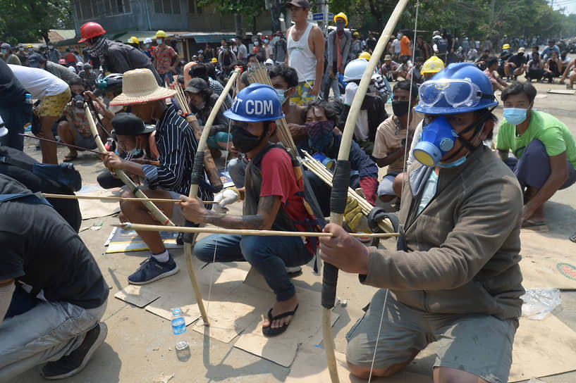 Протестующие с луками и стрелами готовятся противостоять полиции в Янгоне