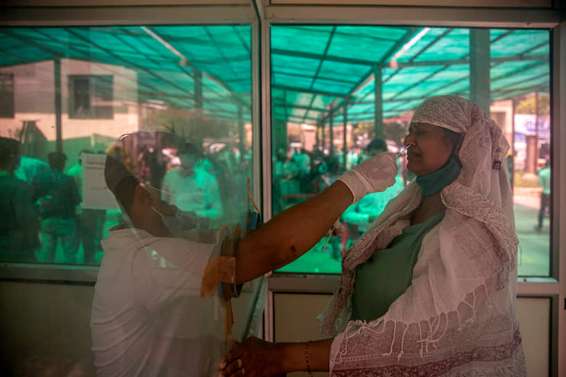 Нью-Дели, Индия. Медработник берет мазок на коронавирус