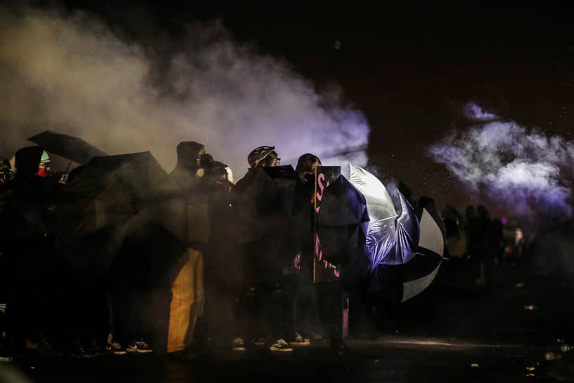Бруклин-Сентер, США. Протестующие прикрываются зонтами от дыма