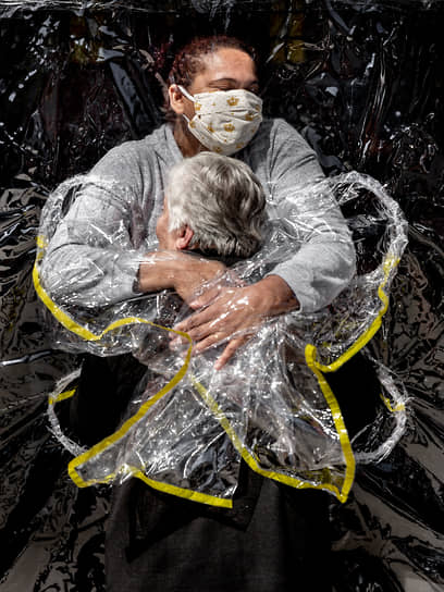 Фотография года — снимок датчанина Мадса Ниссена под названием «Первое объятие», сделанный в августе 2020 года. На нем изображена 85-летняя жительница дома престарелых в Сан-Паулу, которую обнимает медсестра