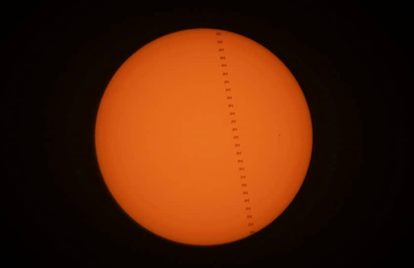 Составное изображение из силуэтов Международной космической станции, пролетающей мимо Солнца