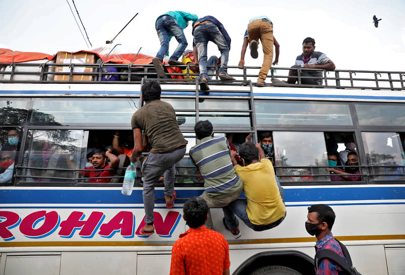 Калькутта, Индия. Рабочие залезают в переполненный автобус 