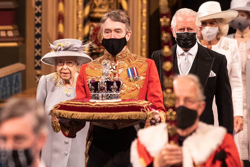 Лондон, Великобритания. Королева Елизавета II с принцем Чарльзом (на фото справа) перед выступлением на сессии парламента 