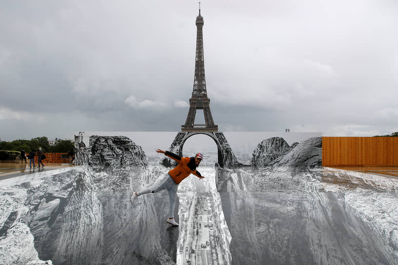 Париж, Франция. Мужчина позирует у художественной инсталляции на площади Трокадеро с видом на Эйфелеву башню
