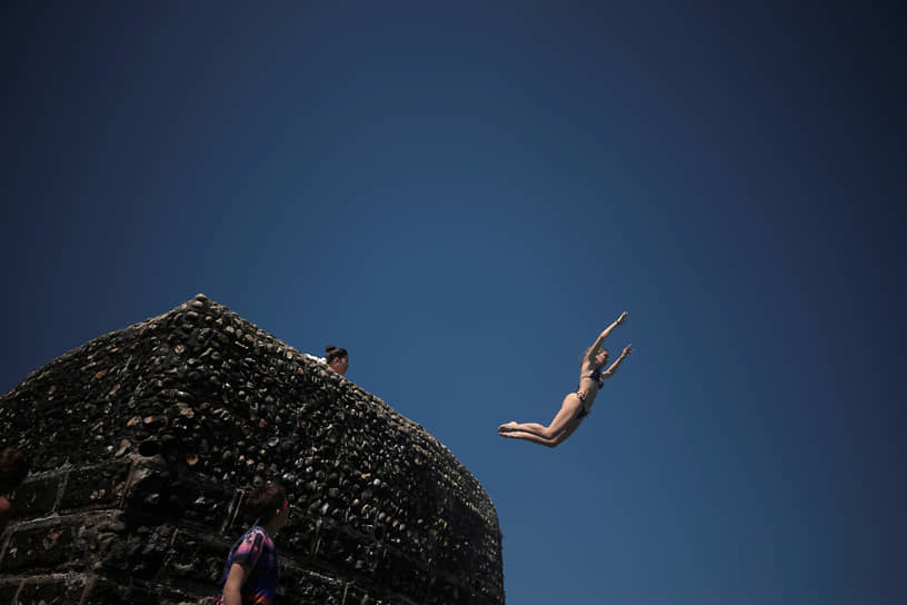 Брайтон, Великобритания. Отдыхающие прыгают в воду пролива Ла-Манш