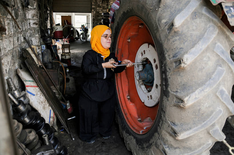 Кафр-эш-Шейх, Египет. Механик ремонтирует колесо трактора в гараже