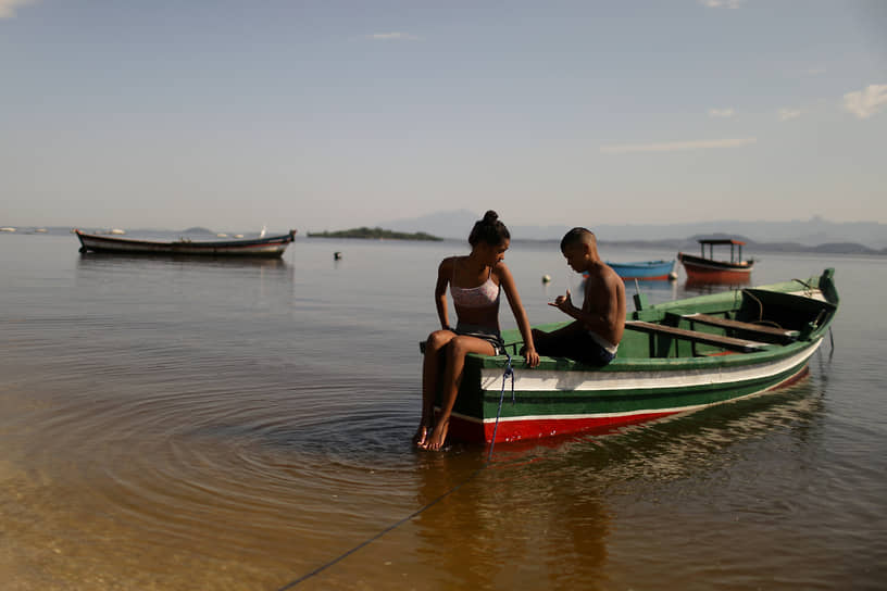 Рио-де-Жанейро, Бразилия. Местные жители отдыхают в лодке на пляже