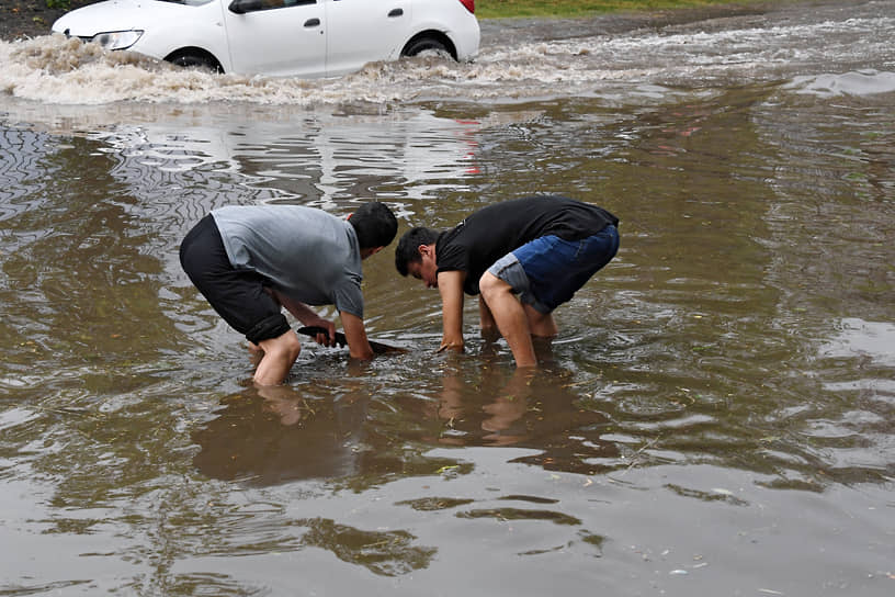 Мужчины пытаются открыть канализационный люк в районе Ясенево 