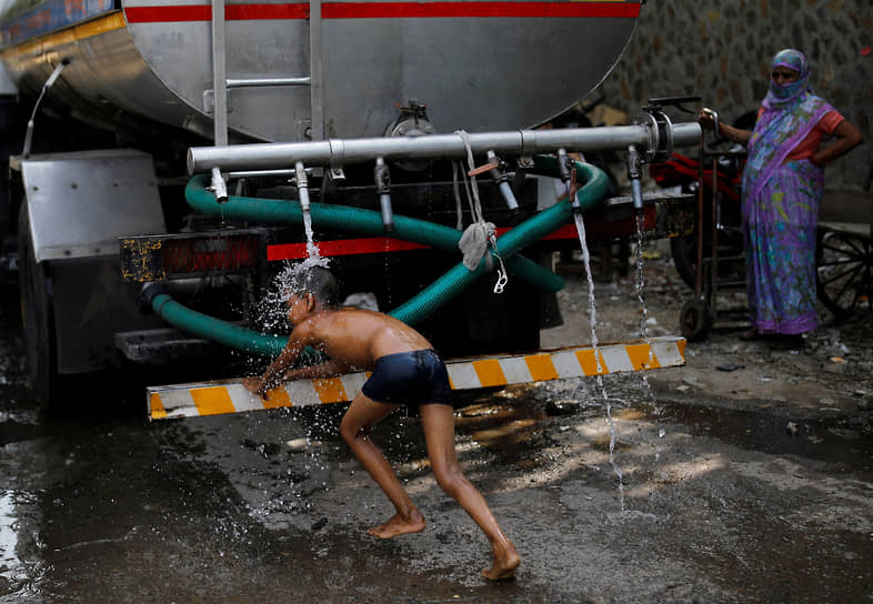 Нью-Дели, Индия. Мальчик умывается под краном городской автоцистерны